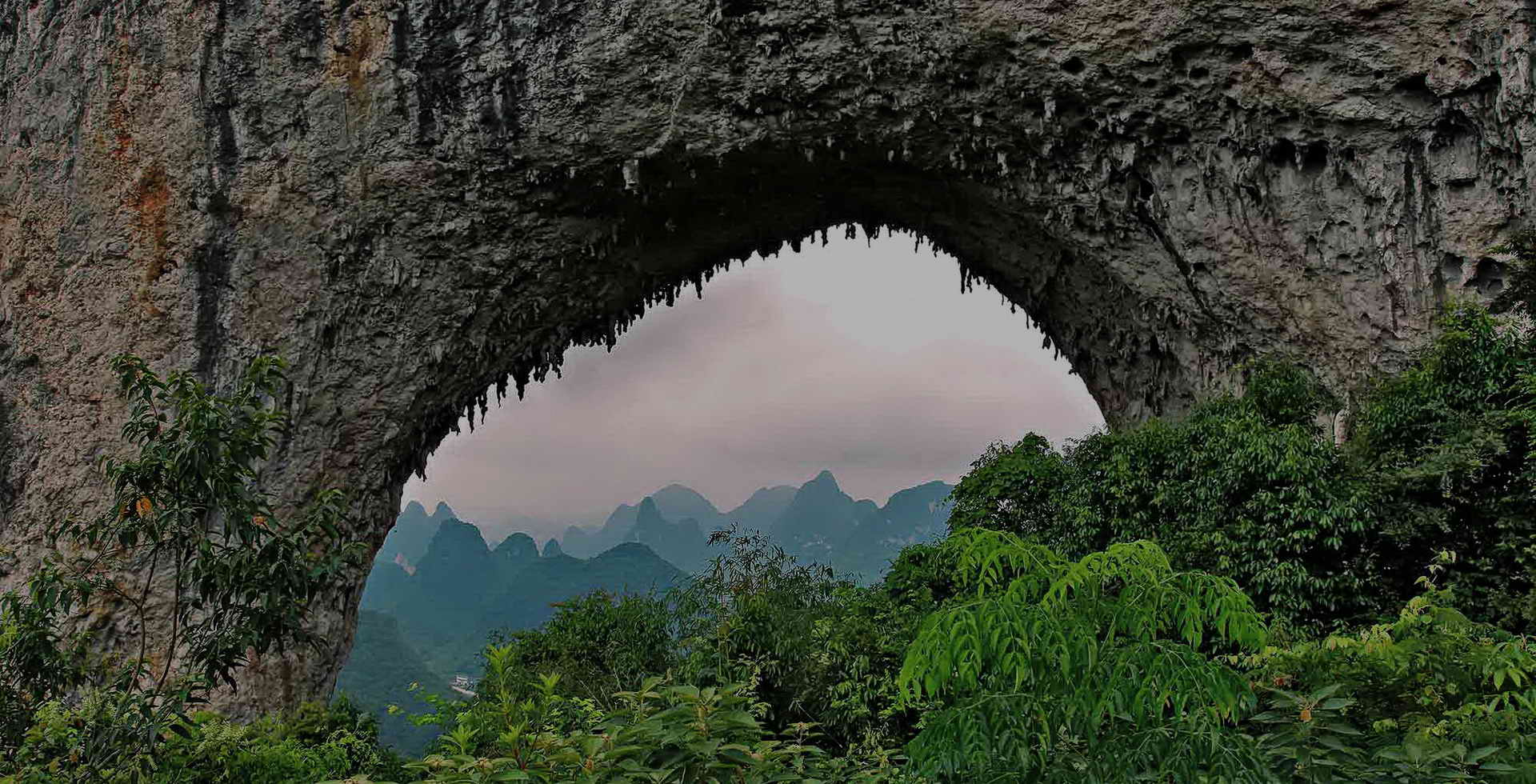 alt=Yangshuo Village Inn with Moon Hill karst mountain backdrop